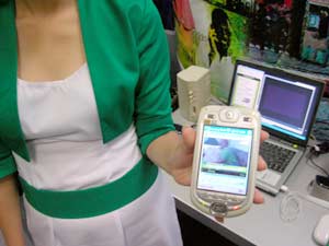 Seorang SPG mendemokan cara menonton televisi  lewat PDA Phone